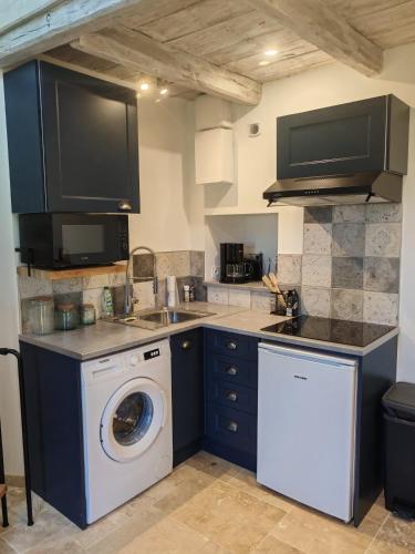 a kitchen with a washing machine and a washer at Gite a collonges la rouge avec spa in Collonges la rouge