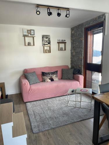 - un canapé rose dans un salon avec un mur en briques dans l'établissement Le Marlotte, aux Carroz d'Arâches