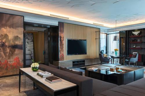 a living room with a couch and a tv at Renaissance Xi'an Hotel in Xi'an