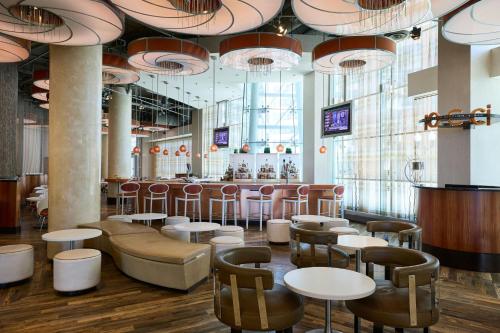a restaurant with tables and chairs and a bar at Renaissance Arlington Capital View Hotel in Arlington