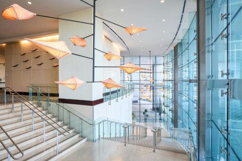 a lobby with stairs and umbrellas on the wall at Renaissance Arlington Capital View Hotel in Arlington