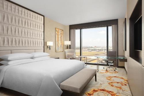 a bedroom with a large white bed and a large window at Sheraton Manila Hotel at Newport World Resorts in Manila