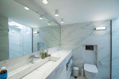 Un baño blanco con lavabo e inodoro. en Amuse Athens Villa, en Vari