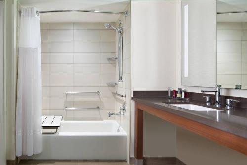 a bathroom with a white tub and a sink at Houston Airport Marriott at George Bush Intercontinental in Houston