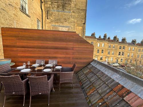 a patio with a table and chairs on a roof at Vintner Townhouse Artisan Quarter Bath in Bath