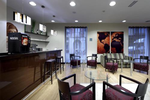 a restaurant with a bar with chairs and a table at Exe Tartessos in Huelva