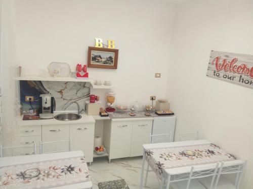a white kitchen with two chairs and a sink at Alessia Sweet Home in SantʼAngelo in Formis