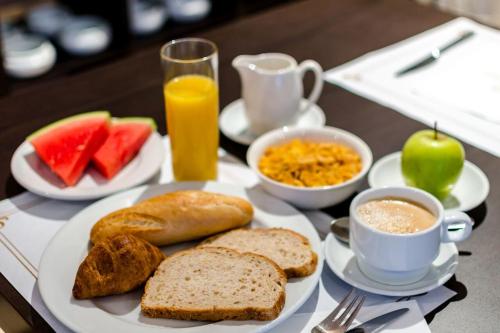 a breakfast table with toast bread and coffee and fruit at Alcalá Plaza in Alcalá de Henares