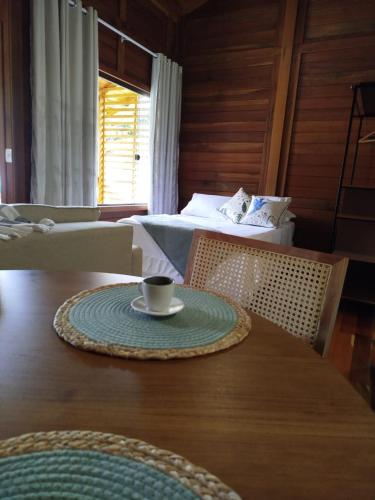 a table with a cup of coffee on top of it at Passarinhada Hospedagem in Domingos Martins
