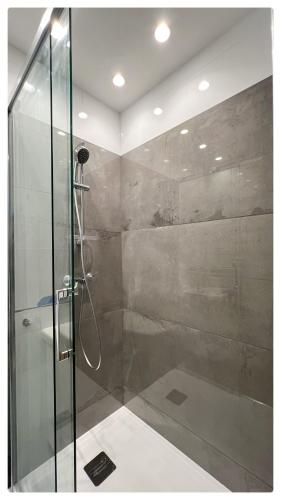 une salle de bain avec une douche avec une porte vitrée dans l'établissement Maison de Côte - Felice, à Nice