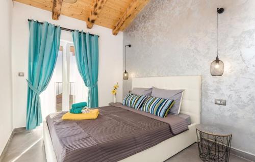 a bedroom with a large bed with blue curtains at Villa Zora with hot tub, Mošćenička Draga - Obrš in Kraj