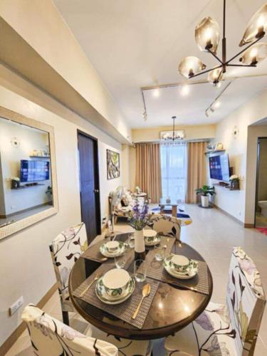 a dining table and chairs in a living room at Bangs Hive at Palladium Megaworld in Iloilo City