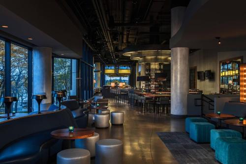 a restaurant with tables and chairs and a bar at Renaissance Toledo Downtown Hotel in Toledo