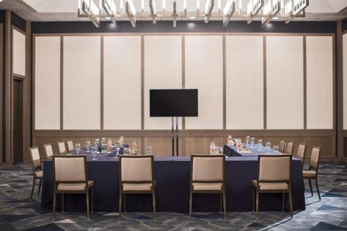 a conference room with a long table with chairs and a tv at Renaissance Toledo Downtown Hotel in Toledo