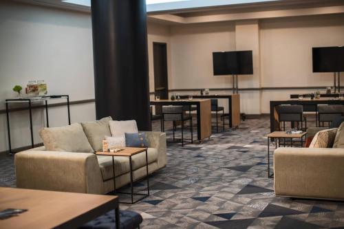 a waiting room with couches and tables and a tv at Renaissance Toledo Downtown Hotel in Toledo
