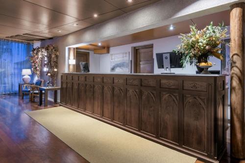 a lobby with a large wooden cabinet with a tv on it at Hotel Palacio del Carmen, Autograph Collection in Santiago de Compostela