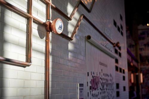 a light shines on a white brick wall with windows at Moxy Washington, DC Downtown in Washington