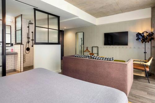 a bedroom with a bed and a tv on the wall at Moxy Washington, DC Downtown in Washington