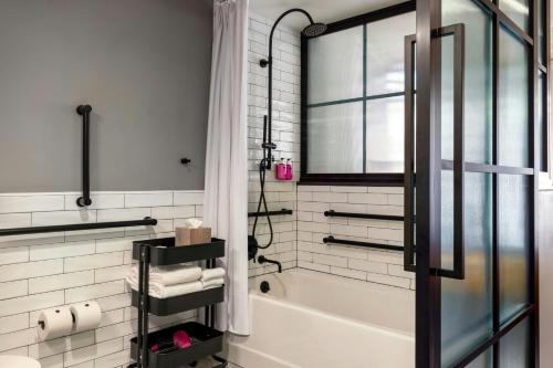 a white bathroom with a tub and a window at Moxy Washington, DC Downtown in Washington
