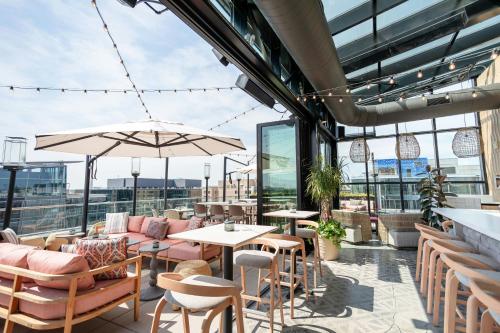 a rooftop patio with tables and chairs and windows at Moxy Washington, DC Downtown in Washington