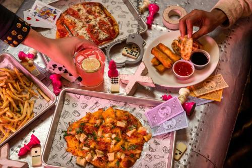 a table topped with plates of food and a pizza at Moxy Washington, DC Downtown in Washington