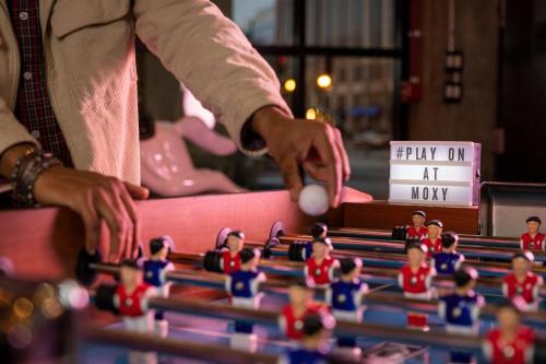 a person playing a game with toy figurines at Moxy Washington, DC Downtown in Washington
