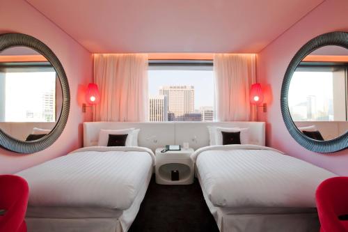 two beds in a room with two mirrors at THE PLAZA Seoul, Autograph Collection in Seoul