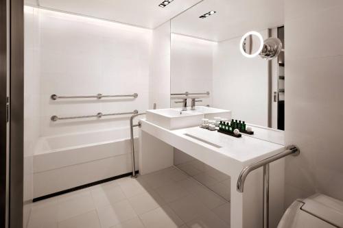 a white bathroom with a sink and a tub at THE PLAZA Seoul, Autograph Collection in Seoul