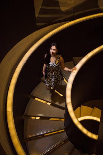 a woman is walking down a spiral staircase at THE PLAZA Seoul, Autograph Collection in Seoul