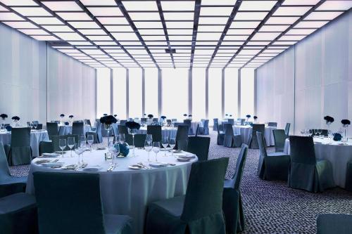 a large room with tables and chairs with white tablecloths at Renaissance Warsaw Airport Hotel in Warsaw