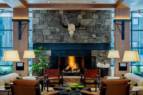 a fireplace in a lobby with a stone wall at The Cloudveil, Autograph Collection in Jackson