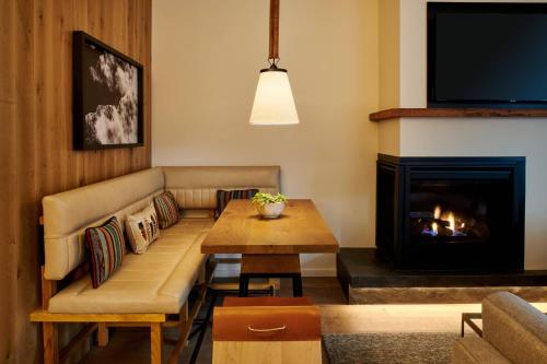 a living room with a couch and a fireplace at The Cloudveil, Autograph Collection in Jackson