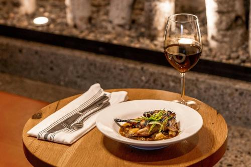 a plate of food and a glass of wine on a table at The Cloudveil, Autograph Collection in Jackson