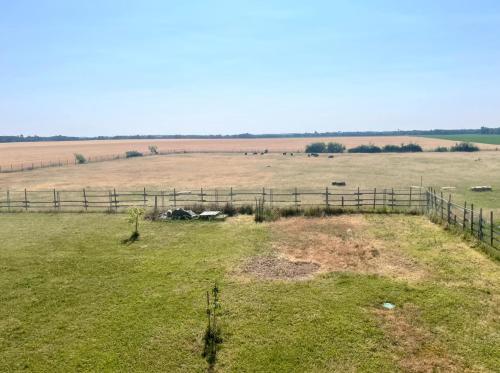 a field with a fence and animals in the distance at Gite de l'Ormes Magnolia in Nanteau-sur-Essonnes