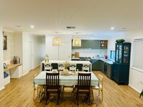a kitchen and dining room with a table and chairs at Cozy Homez Ballarat - Home stay in Alfredton