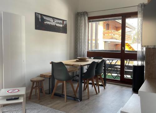une salle à manger avec une table et des chaises et une fenêtre dans l'établissement Le Marlotte, aux Carroz d'Arâches