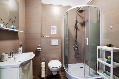 a bathroom with a shower and a toilet and a sink at By the Sea Plusoi Apartment in Năvodari