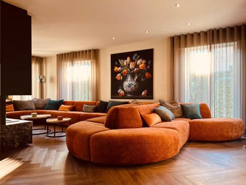 una sala de estar con un gran sofá naranja. en Vakantievilla 't Boshuys, en Lommel