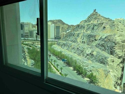 a window with a view of a mountain at عمارة المحيسني in Makkah
