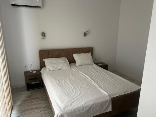 a bedroom with a bed with white sheets and two pillows at Obzor in Obzor