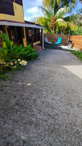 a driveway leading to a house with a blue chair at Villa dousè lavi in Sainte-Anne