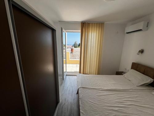 a bedroom with a bed and a door to a balcony at Obzor in Obzor