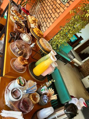 Una mesa con muchos platos de comida encima. en Pousada Tribo Do Sol, en Ubatuba