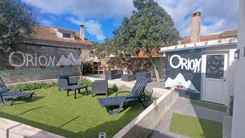 a yard with chairs and a wall with graffiti at Orion Guesthouse Telhado in Fundão