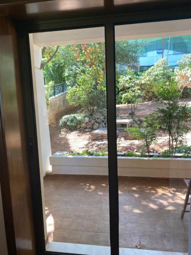 an open glass door with a view of a garden at An eclectic pied a terre in Dionysos in Dhiónisos