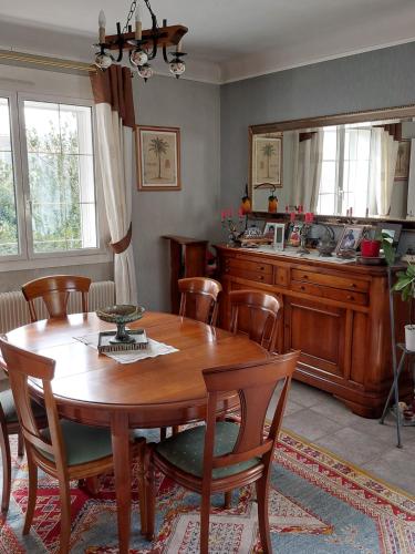 une salle à manger avec une table en bois et une cuisine dans l'établissement Jardin Dangla 