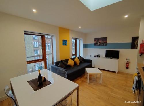 a living room with a couch and a table at Lovely 1 bedroom apartment in South East London in London