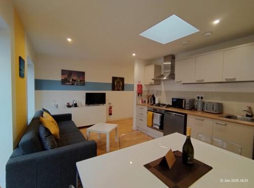 a living room with a blue couch and a kitchen at Lovely 1 bedroom apartment in South East London in London