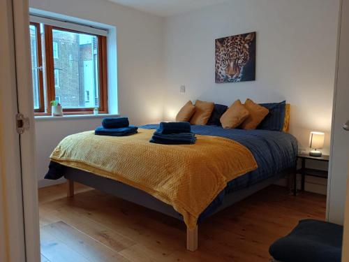 a bedroom with a bed with blue towels on it at Lovely 1 bedroom apartment in South East London in London
