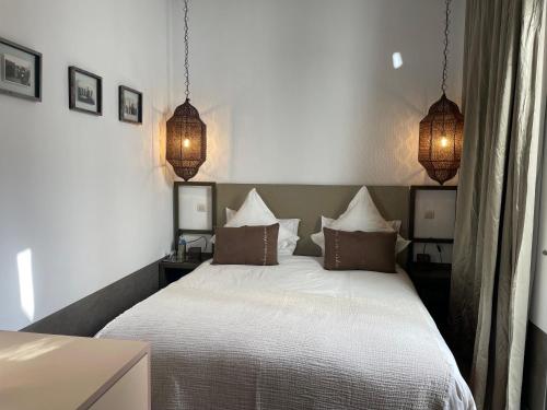 a bedroom with a white bed with three pillows at Riad Dar 73 in Marrakech